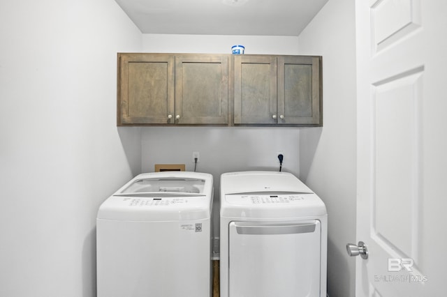 washroom with washing machine and dryer and cabinet space