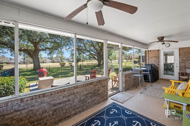 unfurnished sunroom featuring a ceiling fan