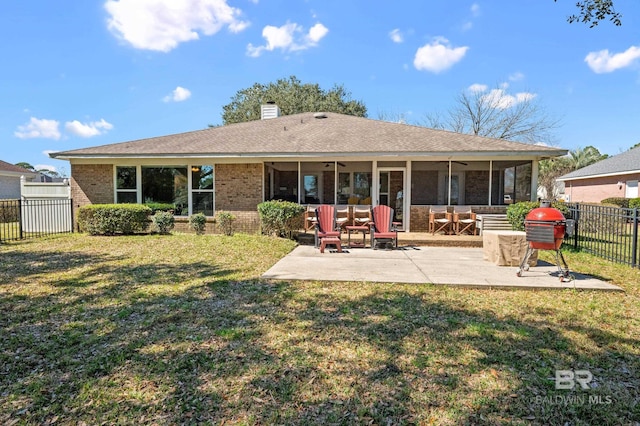 back of property with brick siding, a lawn, a patio area, and a fenced backyard