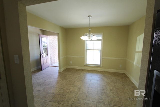 unfurnished room with plenty of natural light and a notable chandelier