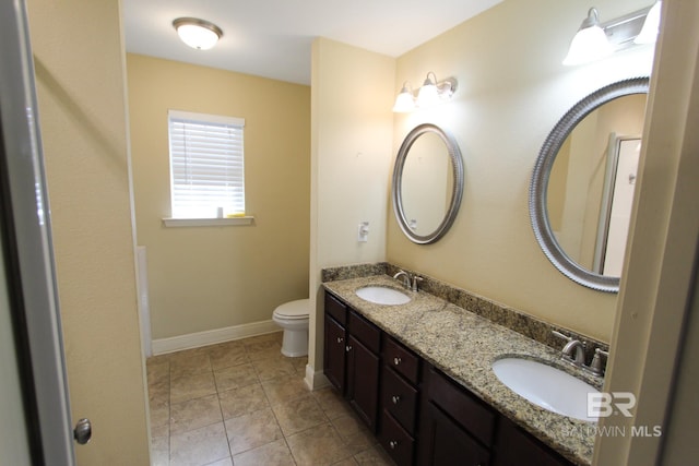 bathroom featuring tile patterned floors, vanity, and toilet