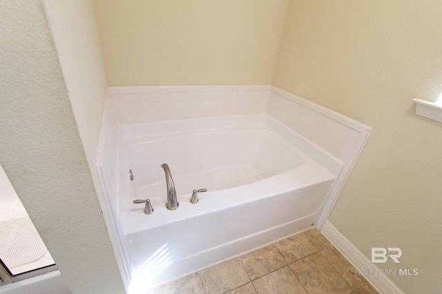 bathroom with tile patterned flooring and a tub