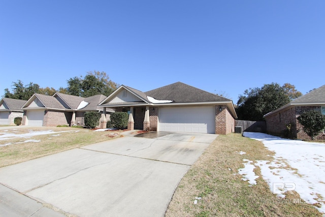 ranch-style home featuring cooling unit, a garage, and a front yard