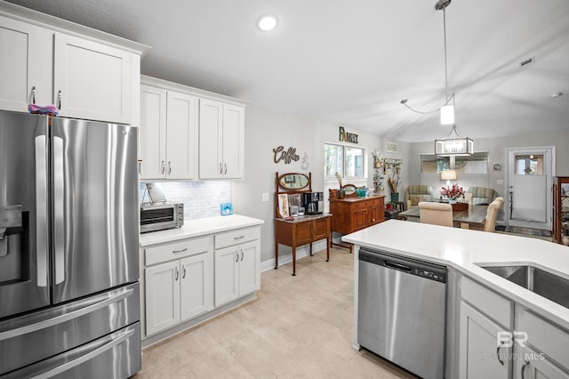 kitchen featuring sink, decorative light fixtures, appliances with stainless steel finishes, decorative backsplash, and white cabinets