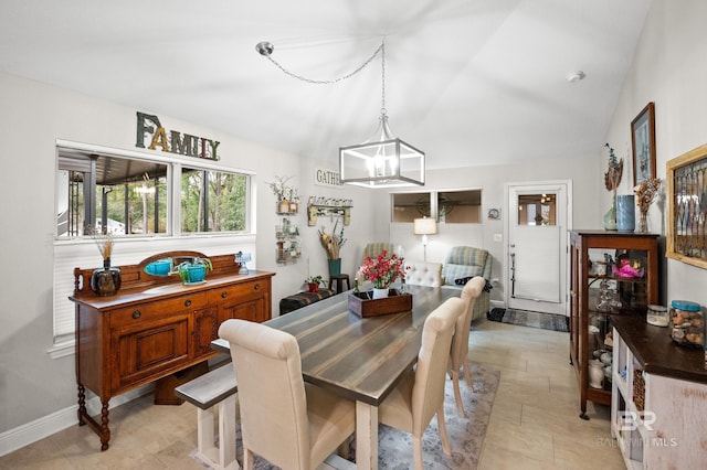 dining space with lofted ceiling and a notable chandelier