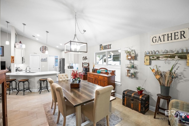 dining room featuring lofted ceiling and sink