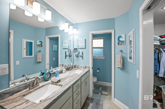 bathroom with vanity, a textured ceiling, and toilet