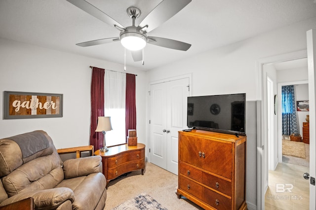 sitting room featuring light carpet and ceiling fan