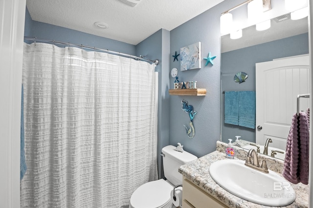 bathroom with vanity, toilet, curtained shower, and a textured ceiling