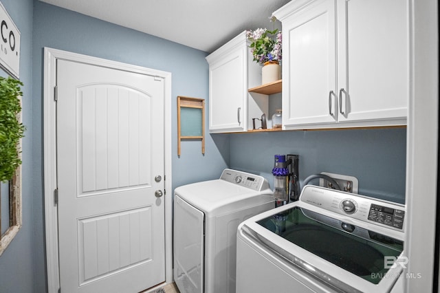 washroom featuring cabinets and washer and dryer