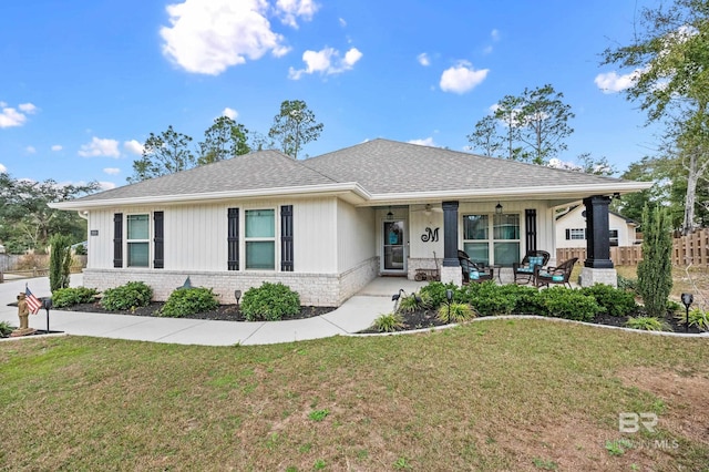 ranch-style house featuring covered porch and a front yard