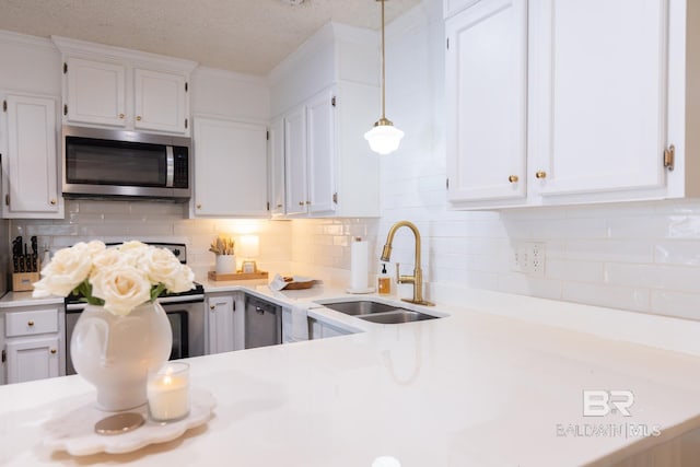 kitchen featuring stainless steel appliances, hanging light fixtures, sink, and white cabinets