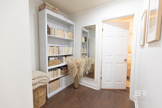 living area featuring crown molding, dark wood-type flooring, and a textured ceiling