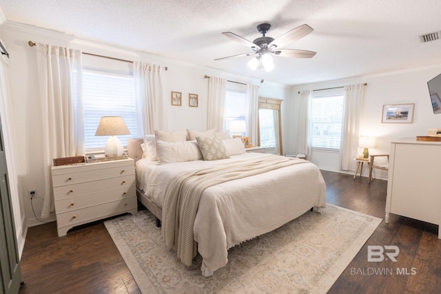 bedroom with dark wood-type flooring, ceiling fan, crown molding, and a textured ceiling