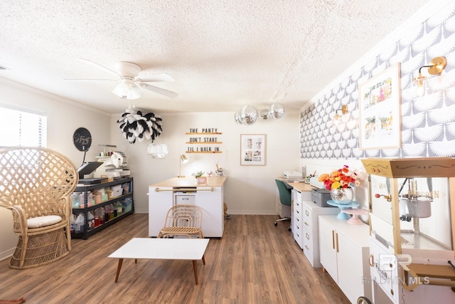 playroom featuring dark hardwood / wood-style flooring, ceiling fan, ornamental molding, and a textured ceiling