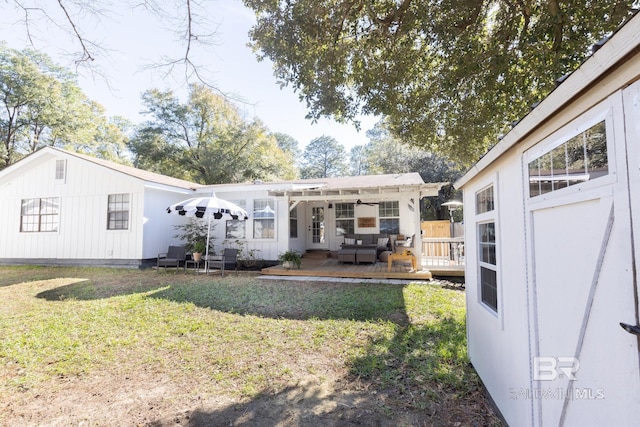 back of house featuring a deck and a lawn