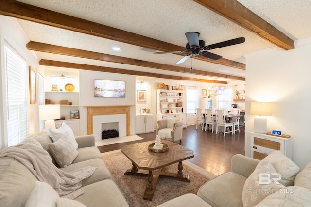 living room with ceiling fan, dark hardwood / wood-style floors, and a textured ceiling