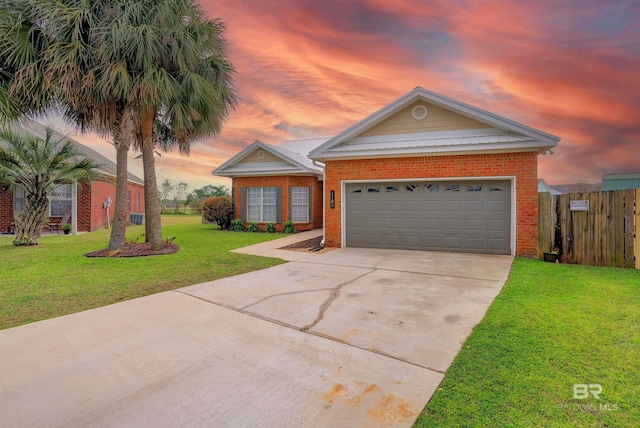 view of front of home featuring brick siding, a lawn, concrete driveway, and fence