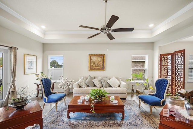 living room with crown molding, hardwood / wood-style floors, ceiling fan, and a tray ceiling