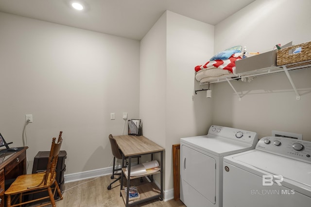 washroom with washing machine and clothes dryer and light hardwood / wood-style flooring