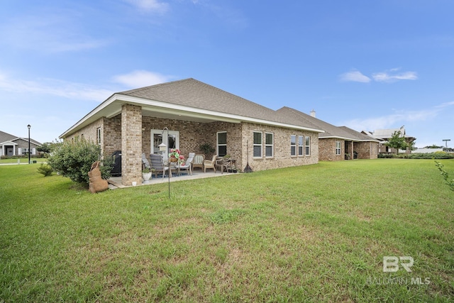 back of property with a patio area and a lawn