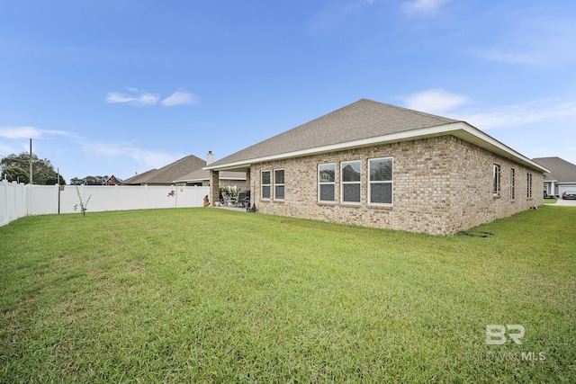 rear view of property with a lawn