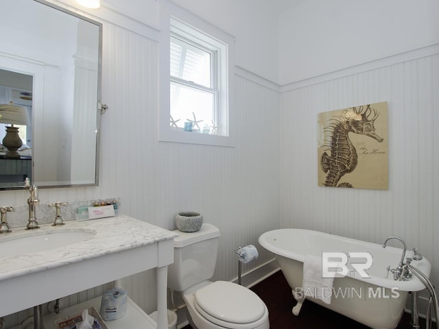 full bath featuring vanity, a soaking tub, and toilet