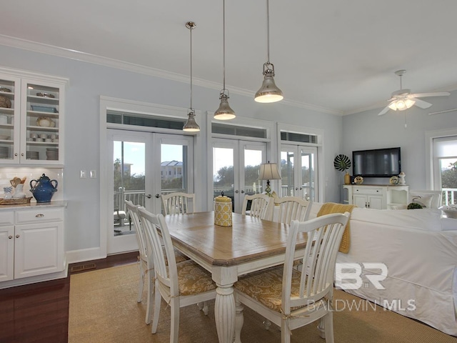 dining room with french doors, dark wood-type flooring, baseboards, and ornamental molding