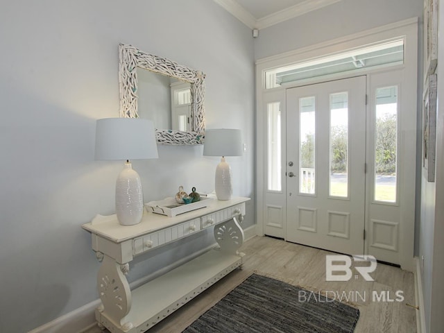 entrance foyer with light wood-style flooring, crown molding, and baseboards