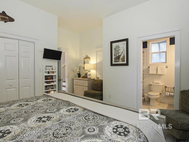 tiled bedroom featuring a closet and ensuite bath