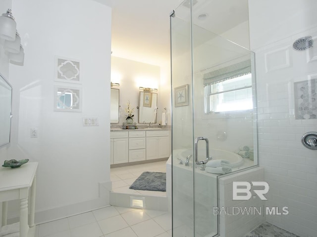 bathroom with vanity, tile patterned floors, baseboards, and a stall shower