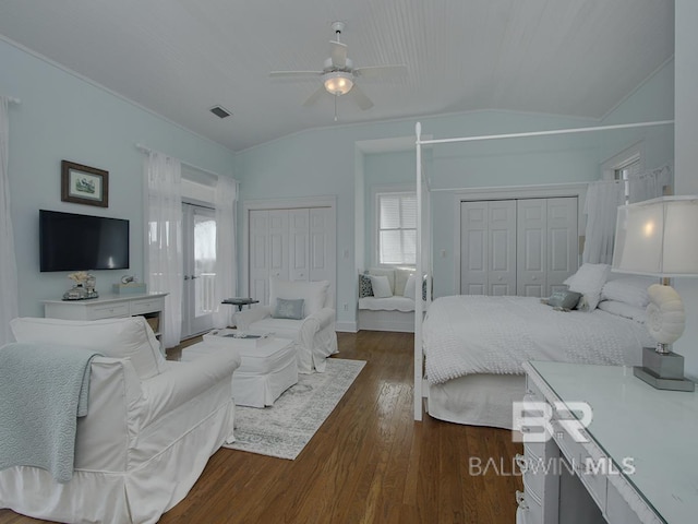 bedroom featuring dark wood finished floors, a ceiling fan, multiple closets, and vaulted ceiling