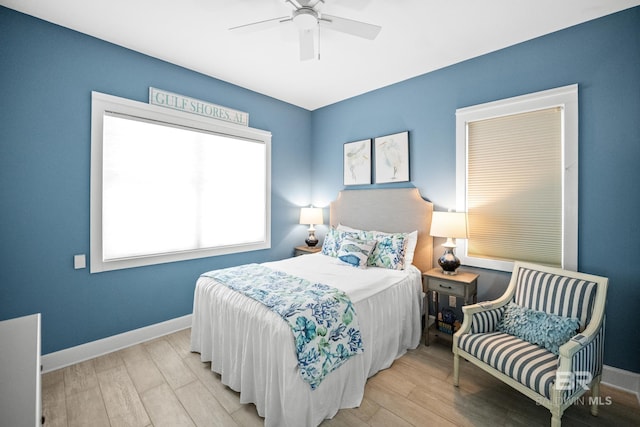 bedroom with a ceiling fan, wood finished floors, and baseboards