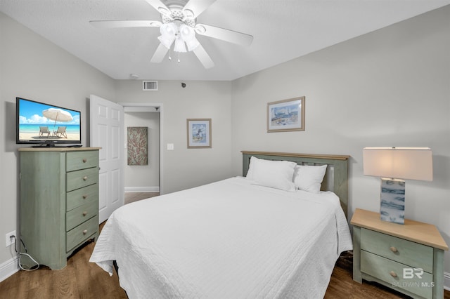 bedroom featuring a textured ceiling, dark hardwood / wood-style flooring, and ceiling fan