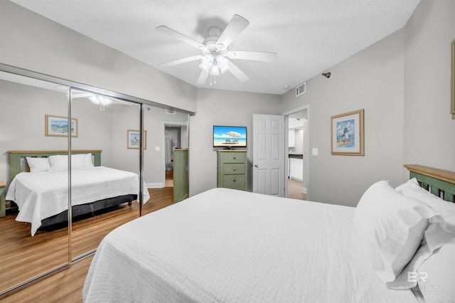 bedroom featuring hardwood / wood-style floors, ceiling fan, and a closet