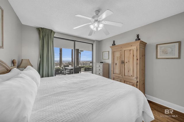 bedroom featuring a textured ceiling, access to outside, ceiling fan, and dark hardwood / wood-style floors
