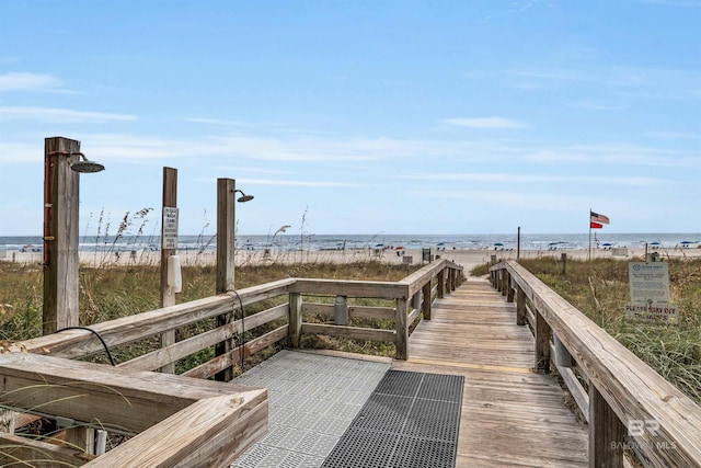 surrounding community with a water view and a beach view