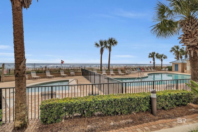 view of pool with a patio and a water view