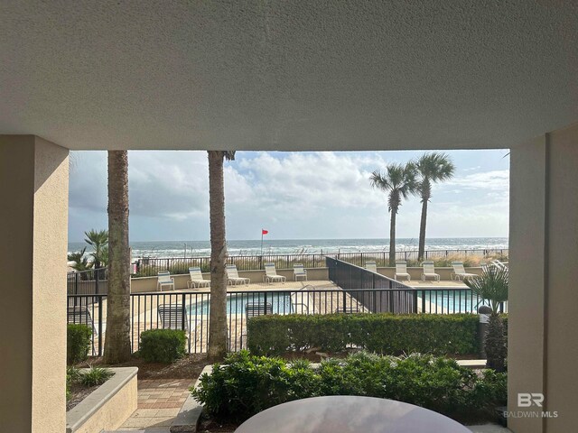 view of patio with a water view and a community pool