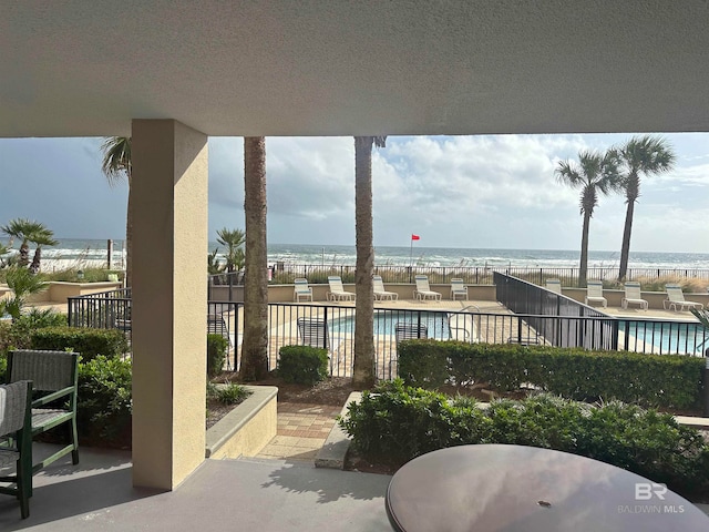 view of patio / terrace with a water view and a community pool