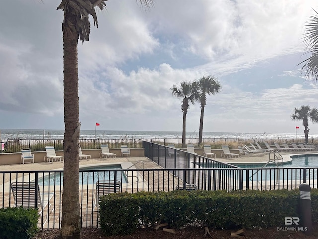 view of swimming pool featuring a water view and a patio area