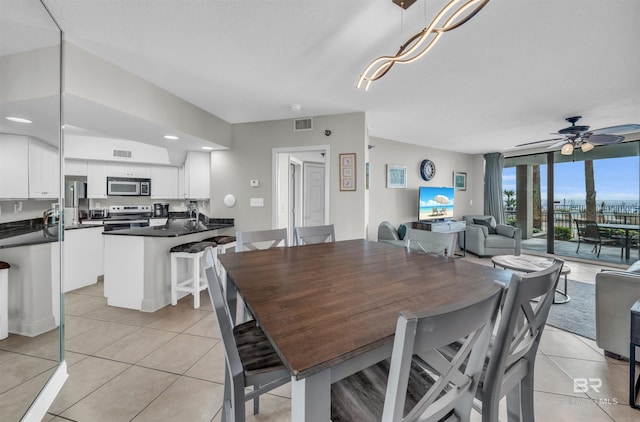 dining space featuring ceiling fan and light tile patterned flooring