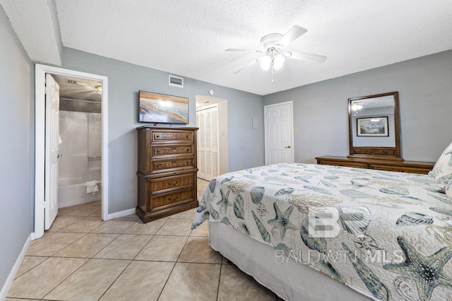 bedroom featuring light tile patterned floors, visible vents, a ceiling fan, a textured ceiling, and baseboards