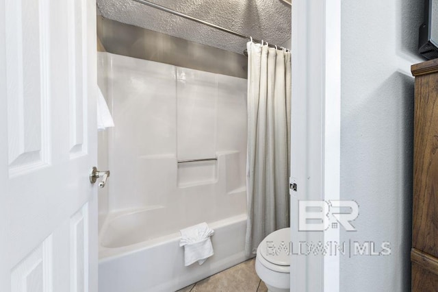 bathroom featuring shower / tub combo, a textured wall, toilet, tile patterned floors, and a textured ceiling