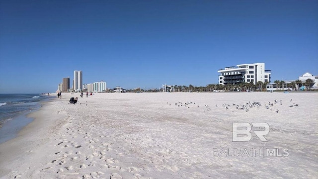 view of yard featuring a view of the beach, a water view, and a view of city