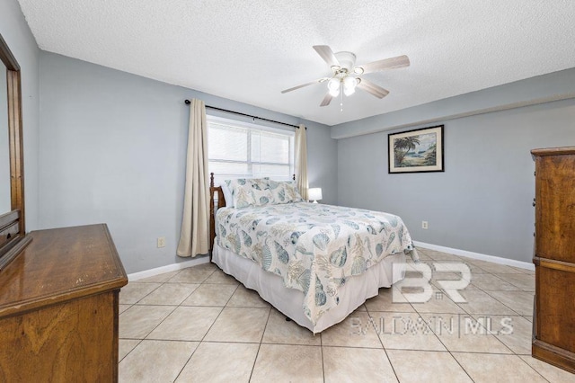 bedroom featuring a ceiling fan, baseboards, a textured ceiling, and light tile patterned flooring