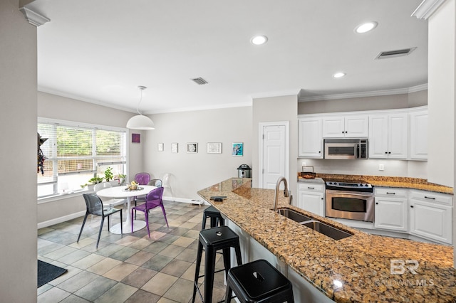 kitchen featuring stainless steel appliances, pendant lighting, white cabinets, and sink