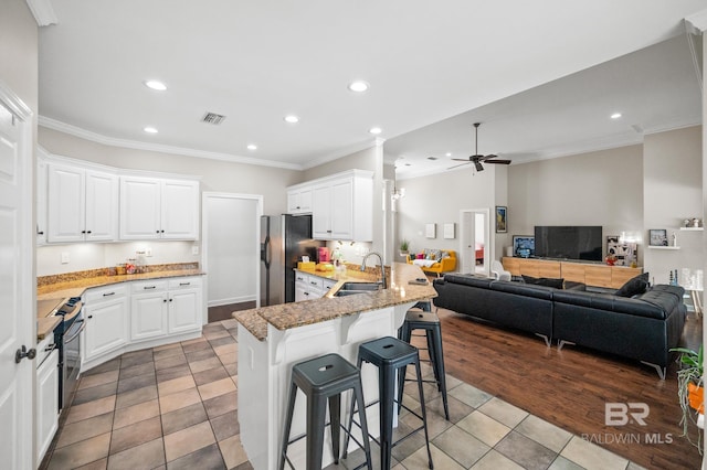 kitchen with kitchen peninsula, white cabinetry, and a kitchen bar