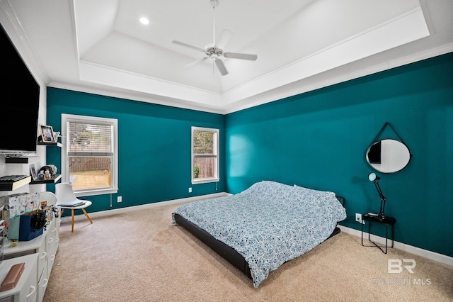 bedroom with a raised ceiling, ceiling fan, carpet, and ornamental molding