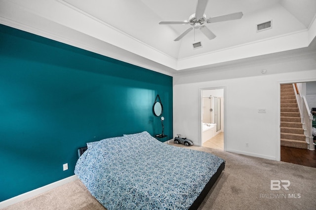 carpeted bedroom with ceiling fan, connected bathroom, a tray ceiling, and ornamental molding